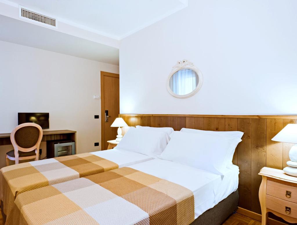 une chambre d'hôtel avec un lit et une chaise dans l'établissement Hotel Ambassador, à Pesaro