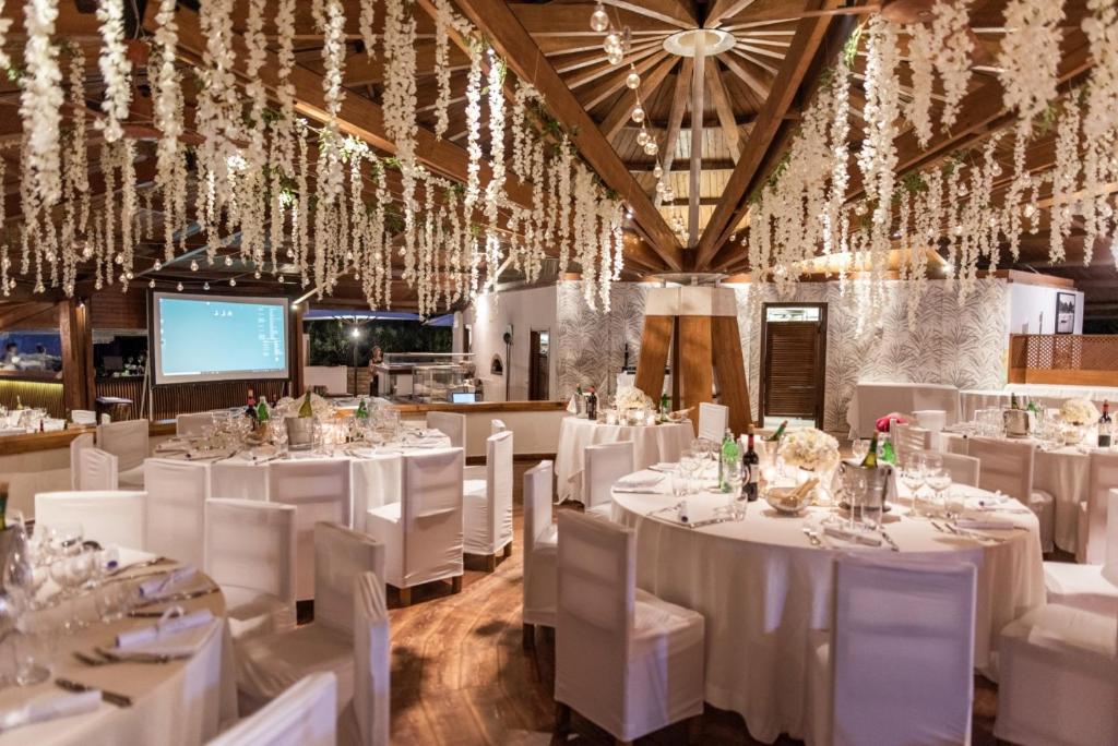 une salle de banquet avec des tables et des chaises blanches dans l'établissement Gallia Palace Hotel - Relais & Châteaux, à Punta Ala 195 autres photos