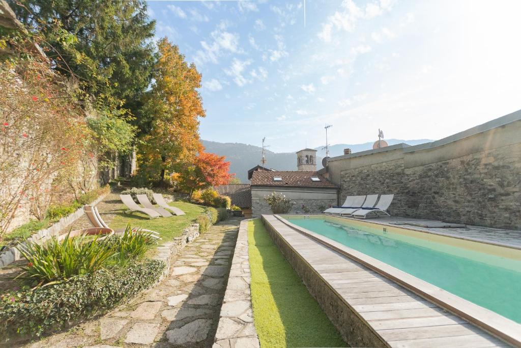 une maison avec une piscine dans une cour dans l'établissement Villa Torre di Palanzo with Magnificent View by Rent All Como, à Faggeto Lario