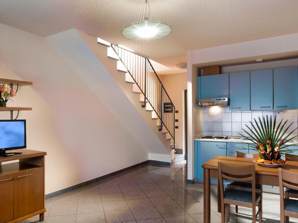 une cuisine et une salle à manger avec des armoires bleues et une table dans l'établissement Continental Resort, à Tirrenia