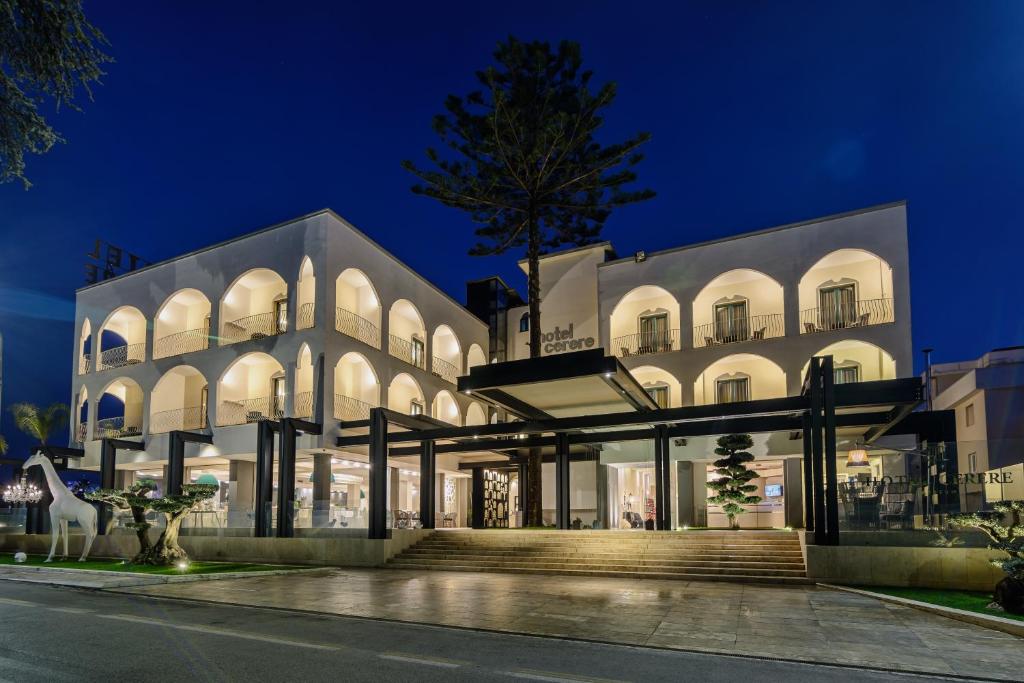 - un grand bâtiment blanc la nuit dans l'établissement Hotel Cerere, à Paestum