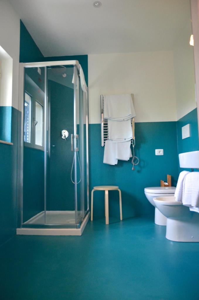 une salle de bain bleue avec une douche et un lavabo dans l'établissement Petit Hotel, à Lido di Camaiore