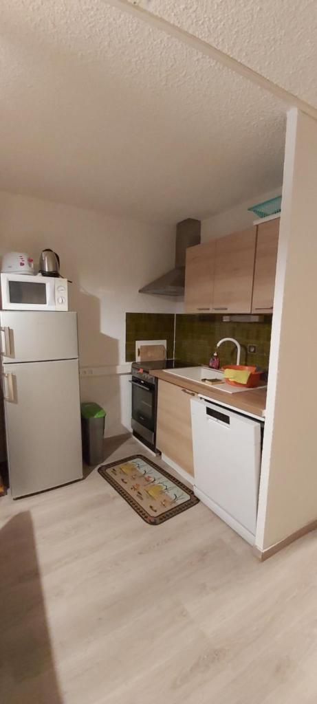 Il comprend une cuisine équipée d'une cuisinière et d'un réfrigérateur blanc. dans l'établissement Idéal pour les vacances, à Selonnet