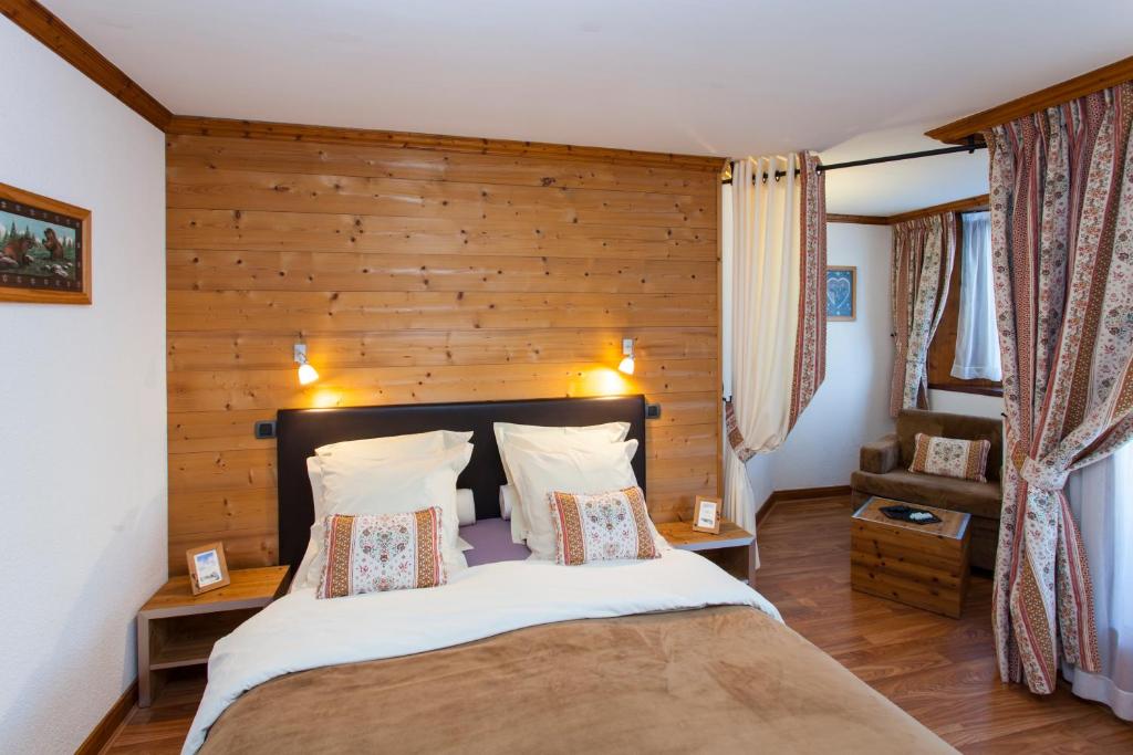 une chambre avec un grand lit avec un mur en bois dans l'établissement Le Calgary, aux Saisies