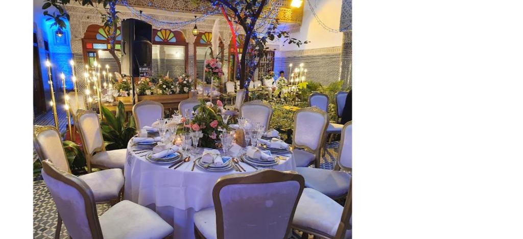 une grande table avec des nappes et des chaises violettes dans l'établissement Riad Les Chrifis Navette Aéroport 24 sur 24, à Fès