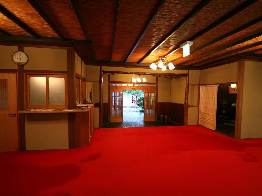 une pièce avec un tapis rouge et un couloir dans l'établissement Nanten-En, à Kawachinagano 37 autres photos