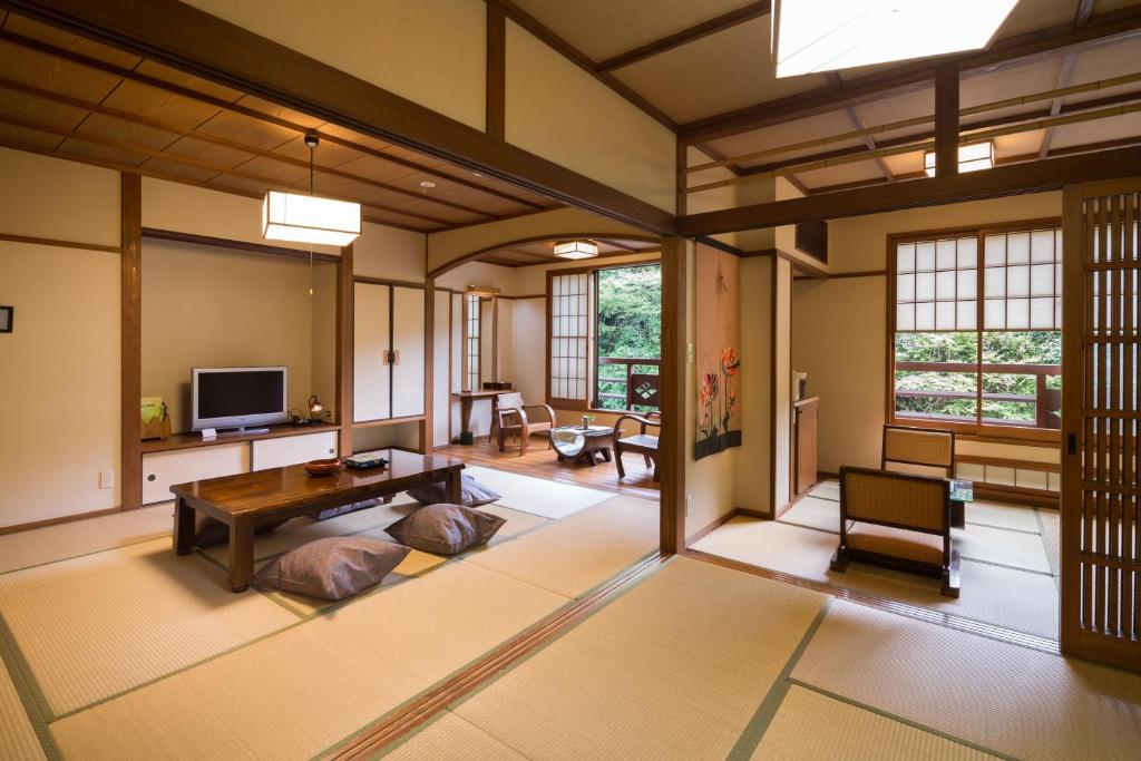 un salon avec une table et une télévision dans l'établissement Yamabiko Ryokan, à Minamioguni