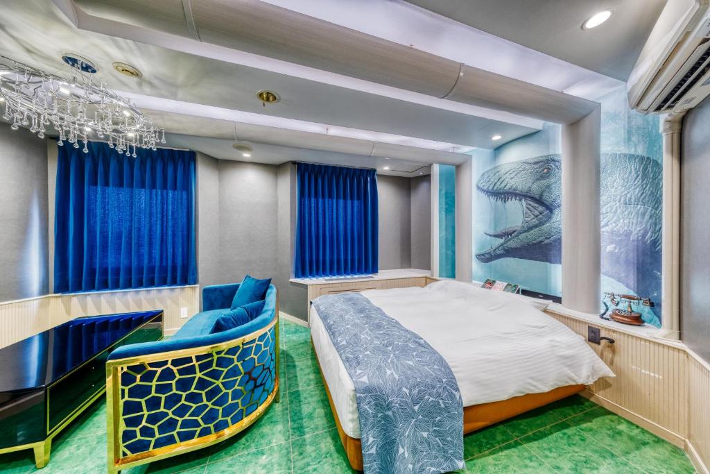 - une chambre avec un grand lit et des chaises bleues dans l'établissement HOTEL ARTIA DINOSAUR MACHIDA -Adult Only, à Kami-seya