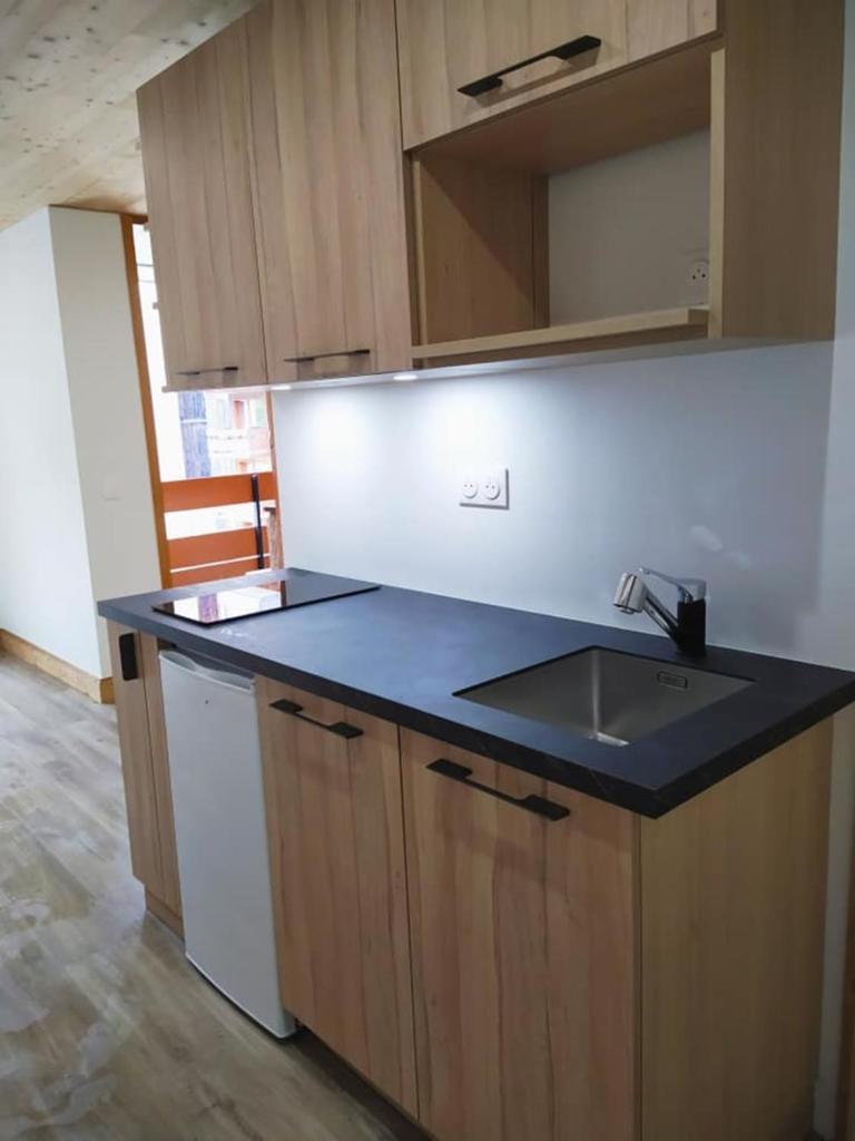 - une cuisine avec un plan de travail noir et un évier dans l'établissement Charming Studio With Balcony, à Mâcot La Plagne