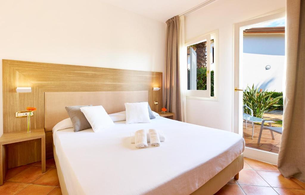 une chambre avec un grand lit blanc et une fenêtre dans l'établissement Paestum Inn Beach Resort, à Paestum