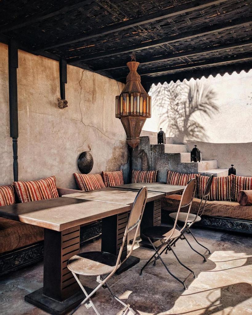 - une table et des chaises dans une chambre avec un canapé dans l'établissement Dar Darma, à Marrakech