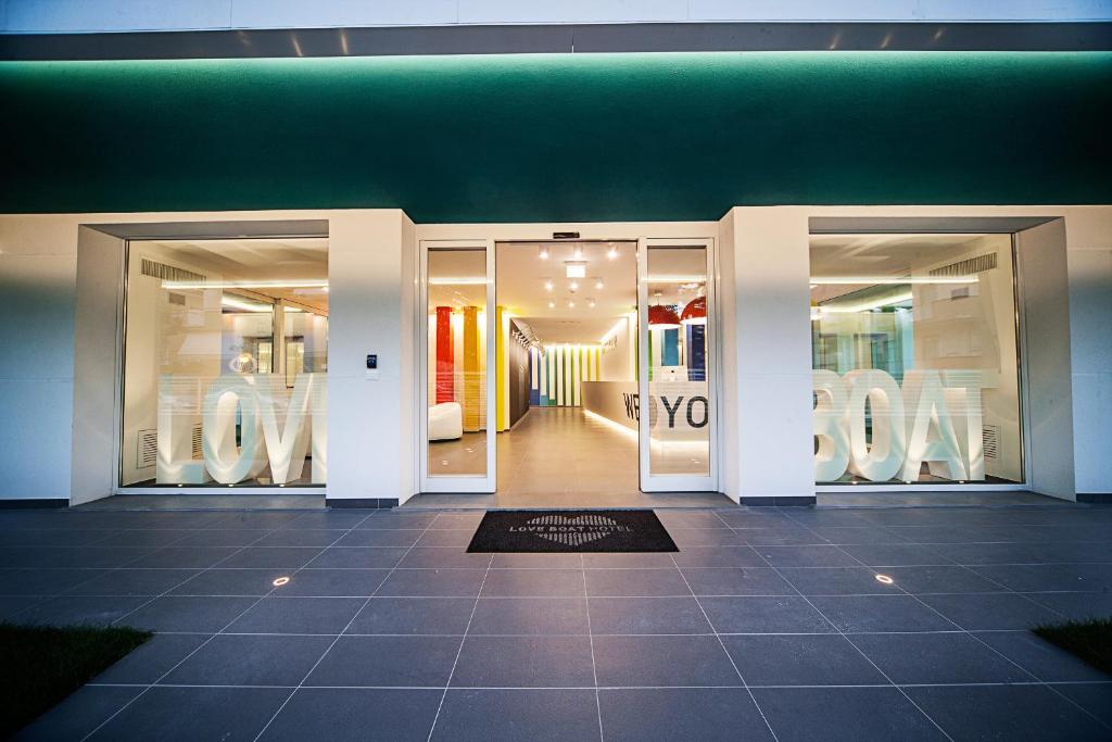 une façade de magasin avec deux portes en verre et un mobilier blanc dans l'établissement Love Boat Hotel - The Original, à Riccione 46 autres photos