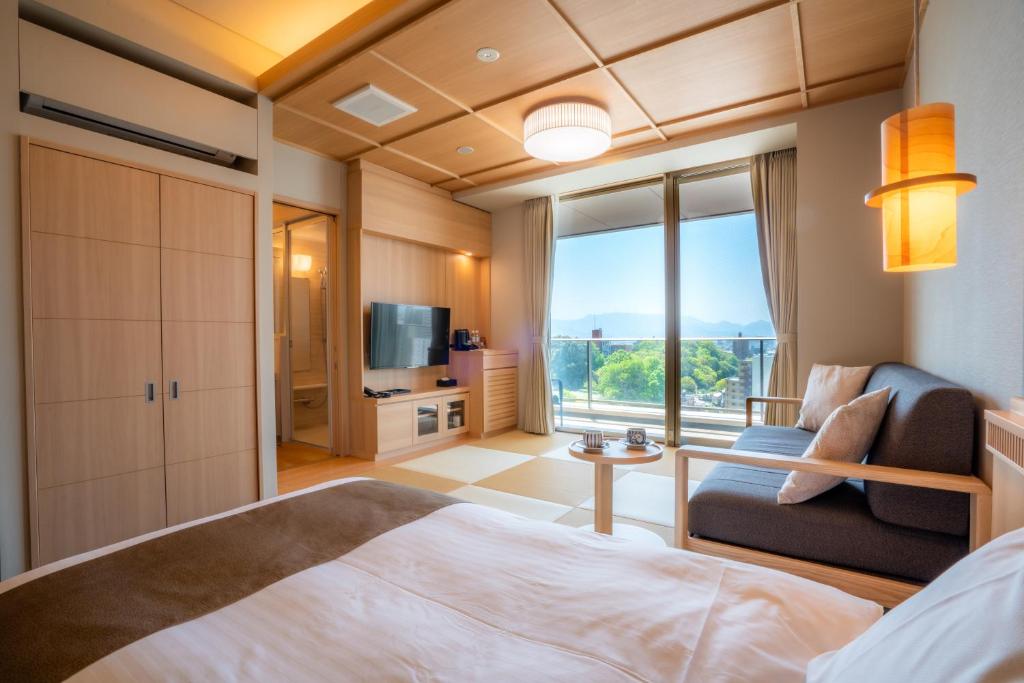 une chambre avec un lit, un canapé et une fenêtre dans l'établissement Kowakuen Haruka, à Matsuyama 37 autres photos