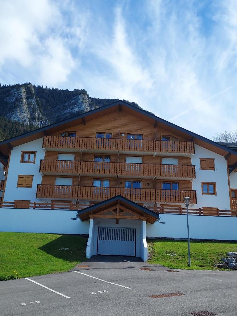 un grand bâtiment avec un balcon au-dessus dans l'établissement Le Rhodo, à Thollon-les-Mémises