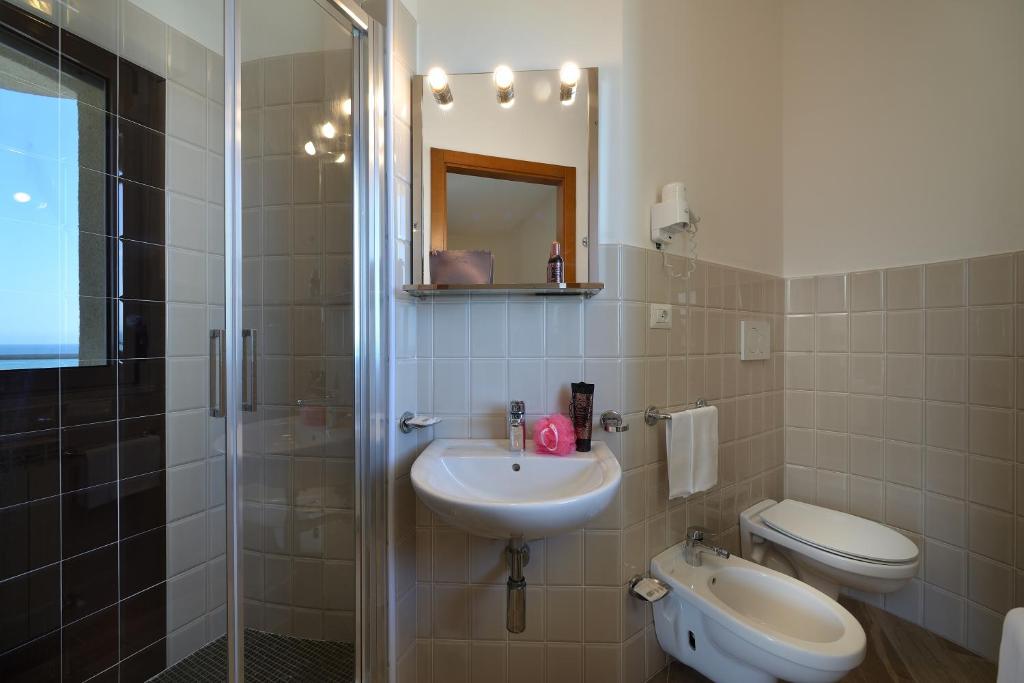 une salle de bain avec un lavabo, des toilettes et une douche dans l'établissement Hotel Nuovo Diana, à Senigallia