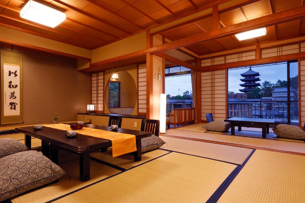 un salon avec une table et des chaises dans un immeuble dans l'établissement Ryokan Asukasou at the entrancne of Nara park, à Nara