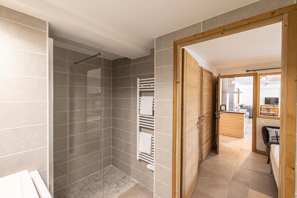une salle de bain avec douche et porte vitrée dans l'établissement Le Loft Alpin, à Oz 37 autres photos