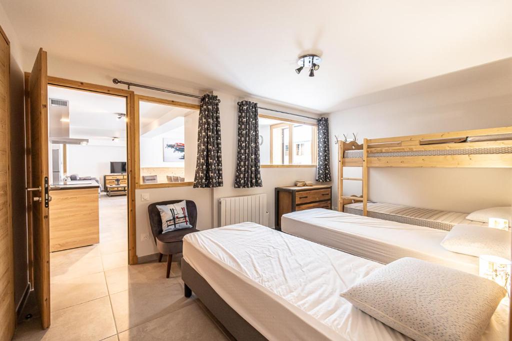 - une chambre avec 2 lits et un bureau dans l'établissement Le Loft Alpin, à Oz
