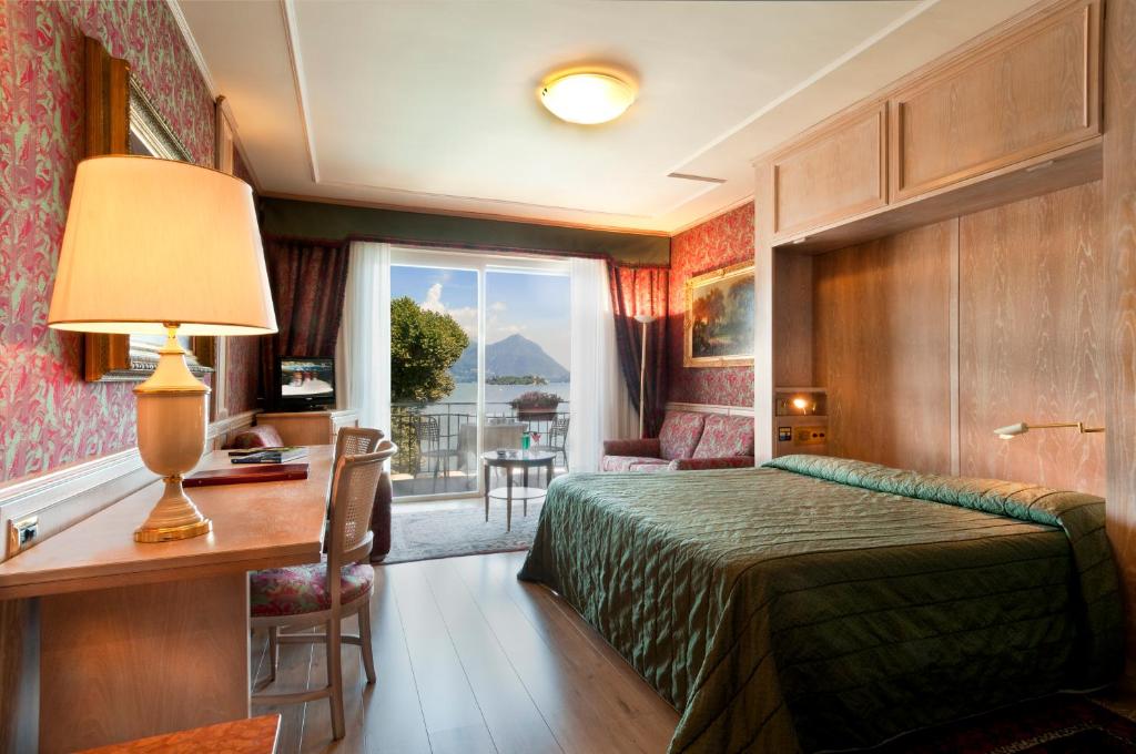 une chambre d'hôtel avec un lit, un bureau et une fenêtre dans l'établissement Grand Hotel Dino, à Baveno 212 autres photos