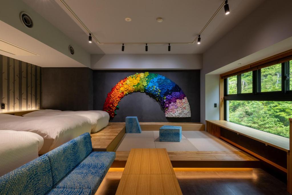 Cette chambre comprend 2 lits et une fresque murale arc-en-ciel. dans l'établissement Sake Hotel Tamakiya, à Tōkamachi 71 autres photos