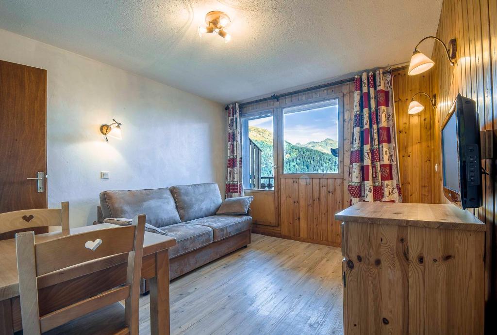 un salon avec un canapé et une table dans l'établissement Le Panoramic, à La Rosière