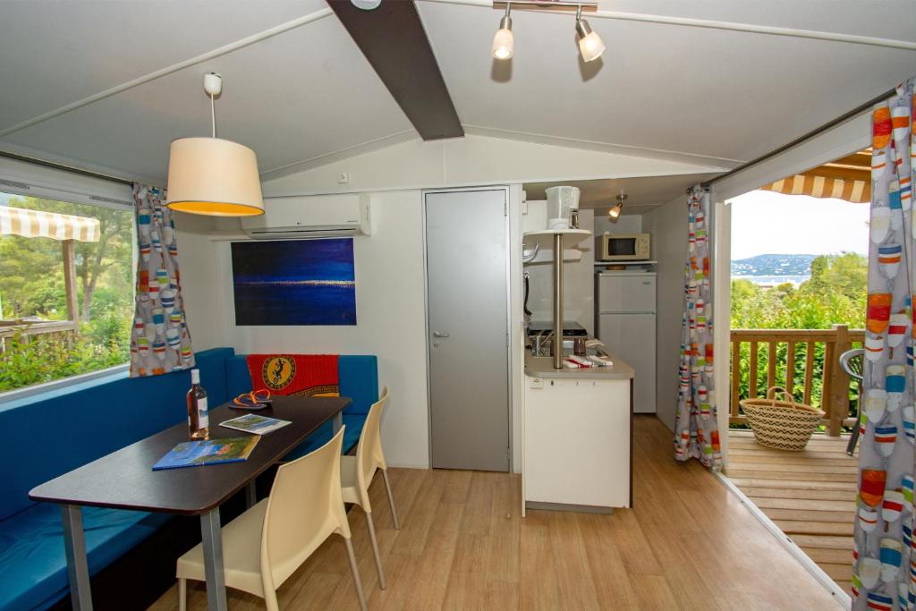 une cuisine et une salle à manger avec une table et des chaises dans l'établissement Camping de la Baie, à Cavalaire-sur-Mer