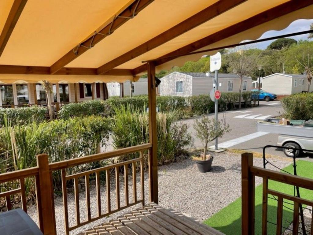 - une terrasse couverte avec un auvent et une vue sur une rue dans l'établissement Mobil Home, à Fréjus