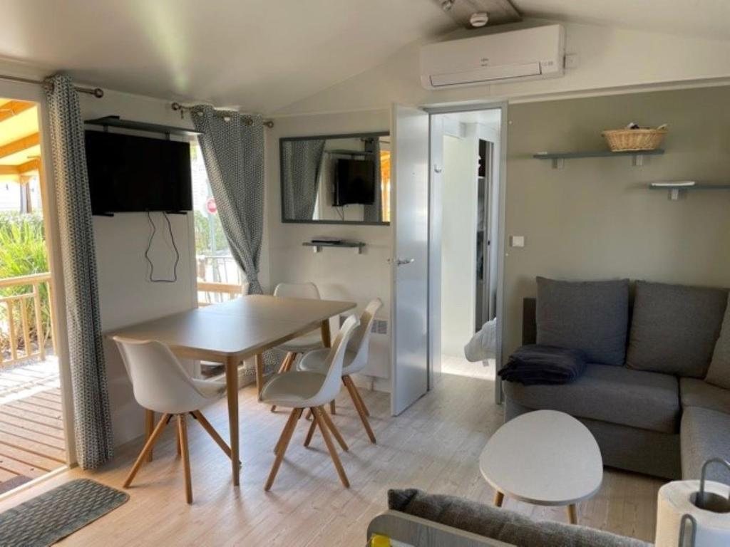 un salon avec une table, des chaises et un canapé dans l'établissement Mobil Home, à Fréjus