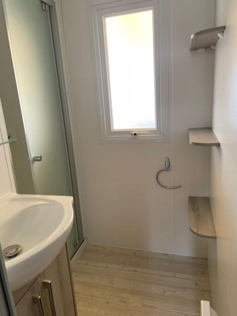 une salle de bain avec un lavabo et une fenêtre dans l'établissement Mobil Home, à Fréjus 18 autres photos