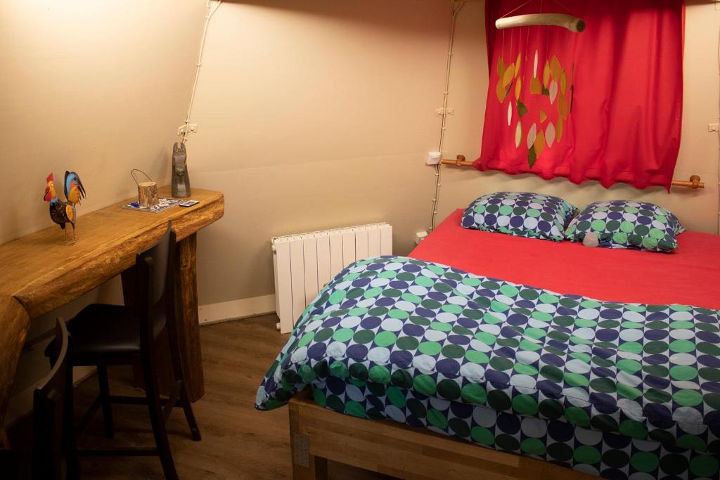 une chambre avec un lit et un bureau avec un bureau dans l'établissement Les Bulles de la Maison du Rocher, à Noisy-sur-École