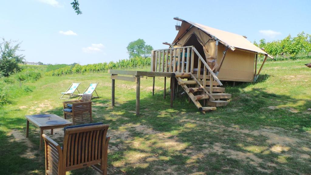une cabine avec une terrasse et des chaises dans un champ dans l'établissement LOVE HORIZON, à Monprimblanc