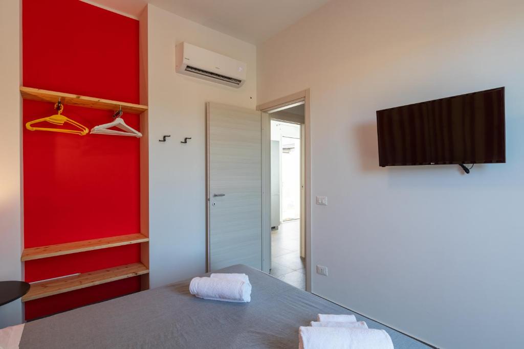 une chambre avec un lit et une télévision sur un mur dans l'établissement Villa con Piscina vicino San Vito Lo Capo, à Custonaci