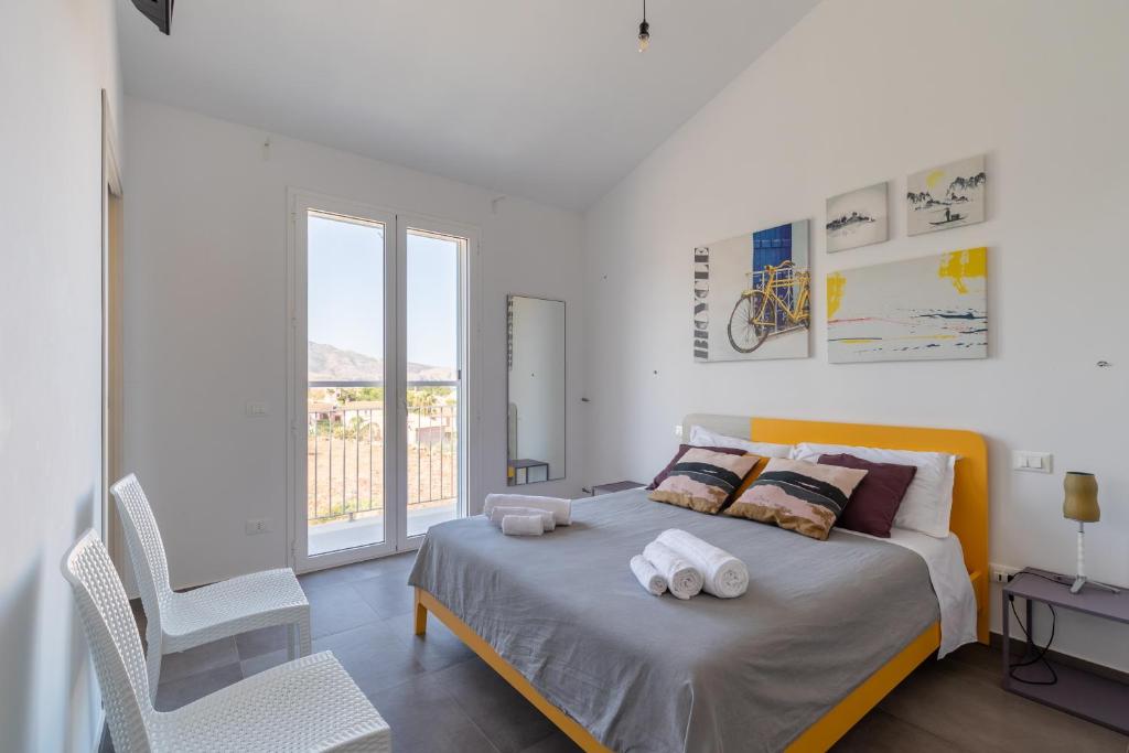 une chambre blanche avec un lit avec des serviettes dessus dans l'établissement Villa con Piscina vicino San Vito Lo Capo, à Custonaci