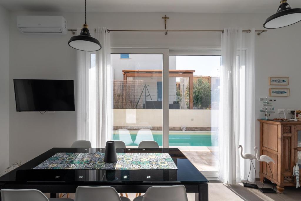 - une salle à manger avec une table et une vue sur la piscine dans l'établissement Villa con Piscina vicino San Vito Lo Capo, à Custonaci