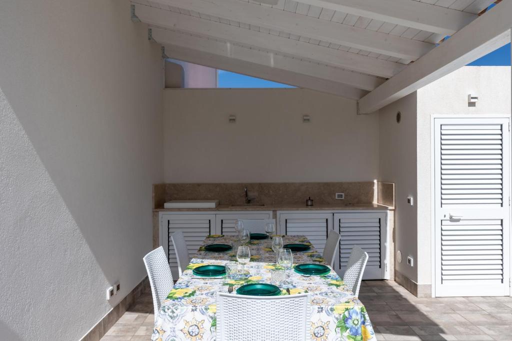 une salle à manger avec une table et des plats verts dans l'établissement Villa con Piscina vicino San Vito Lo Capo, à Custonaci