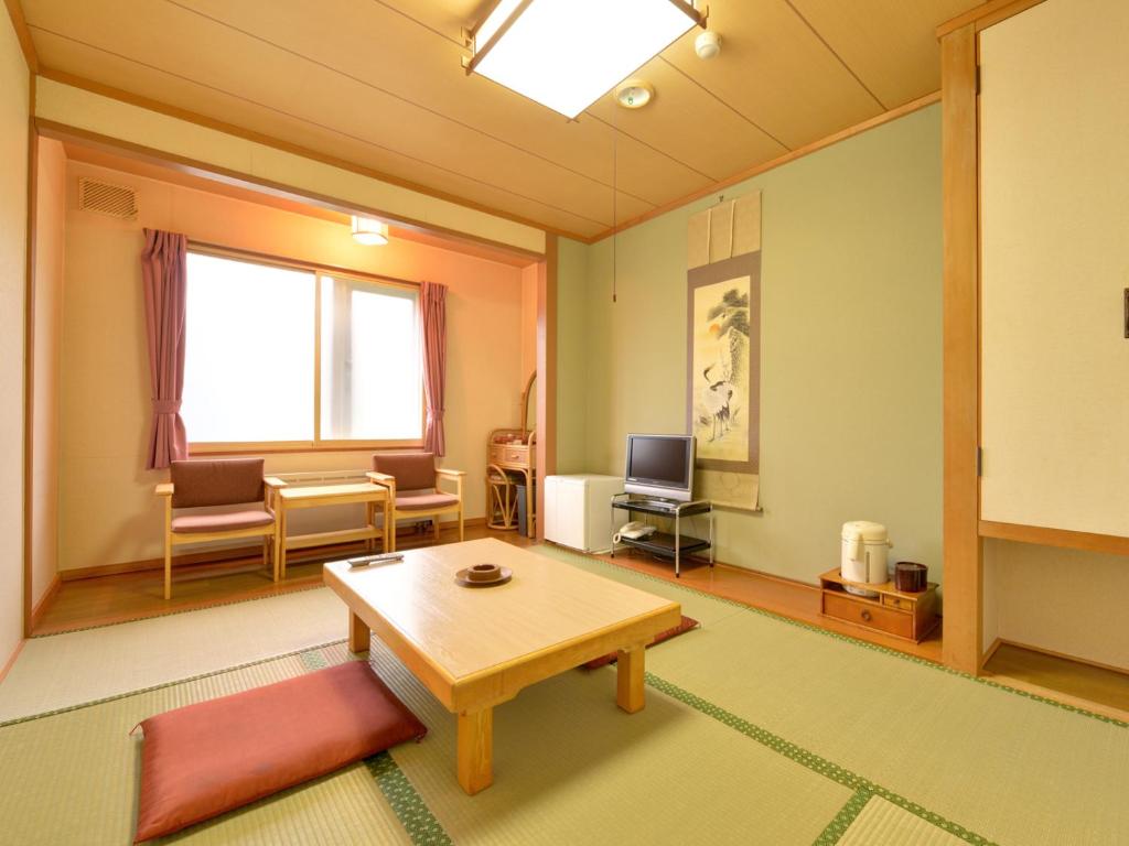 un salon avec une table et des chaises et une fenêtre dans l'établissement Hotel Parkway, à Teshikaga