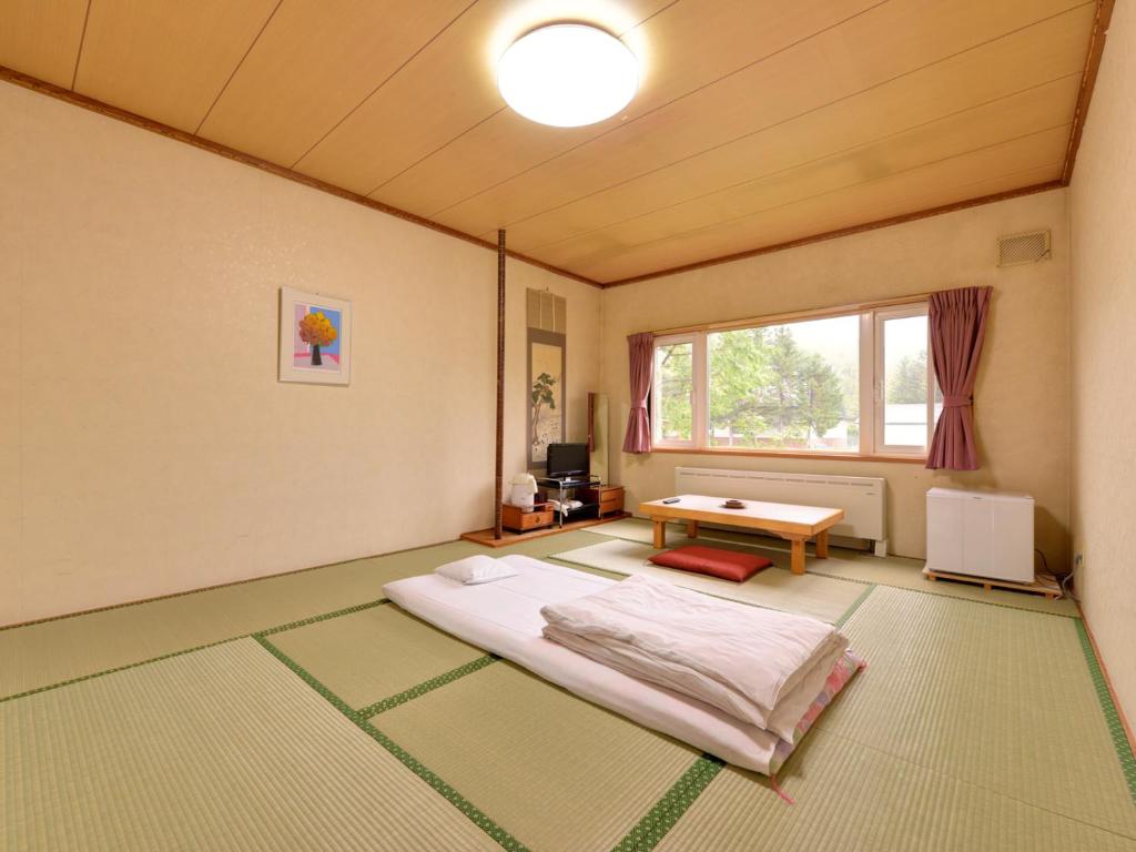 une pièce avec un lit et une table dedans dans l'établissement Hotel Parkway, à Teshikaga