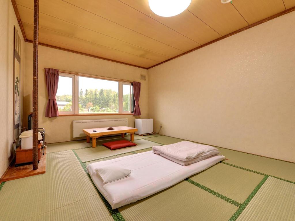 une pièce avec un lit et une table dedans dans l'établissement Hotel Parkway, à Teshikaga