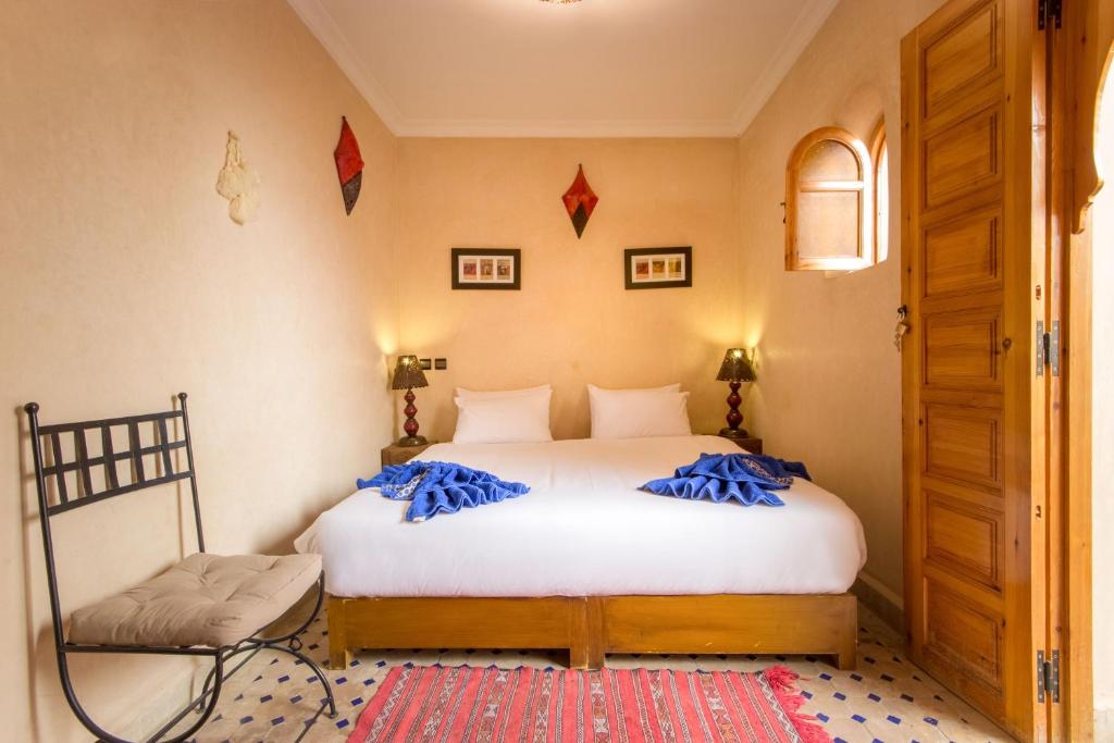 une chambre avec un lit avec des oreillers bleus dessus dans l'établissement Riad Colette EXCLUSIF - Médina - Breakfast - Wifi, à Marrakech