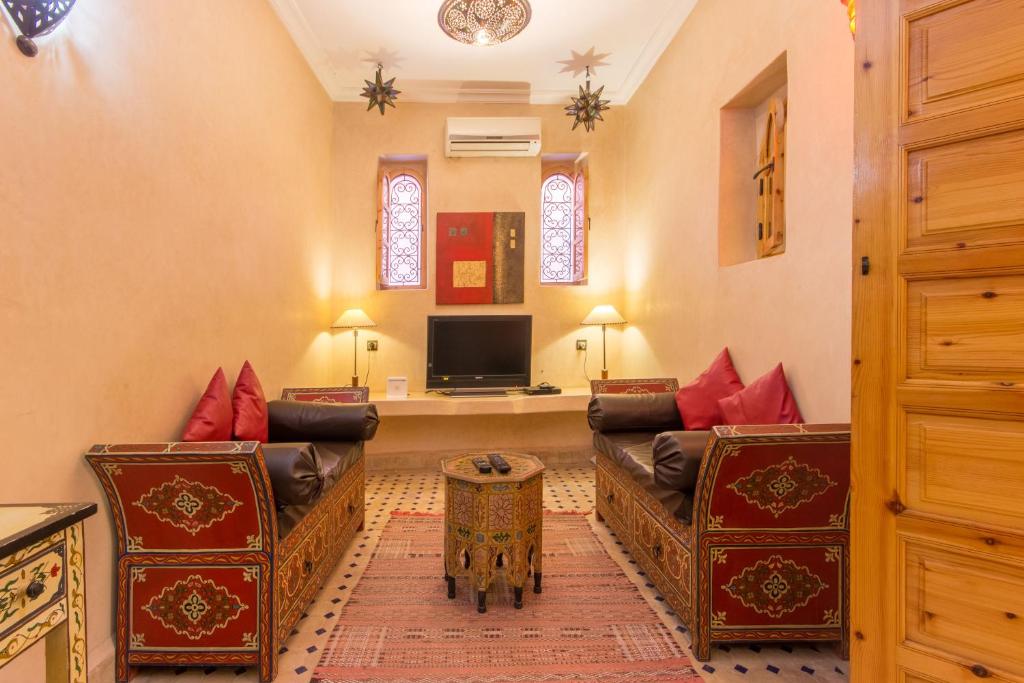 un salon avec deux canapés et une télévision dans l'établissement Riad Colette EXCLUSIF - Médina - Breakfast - Wifi, à Marrakech