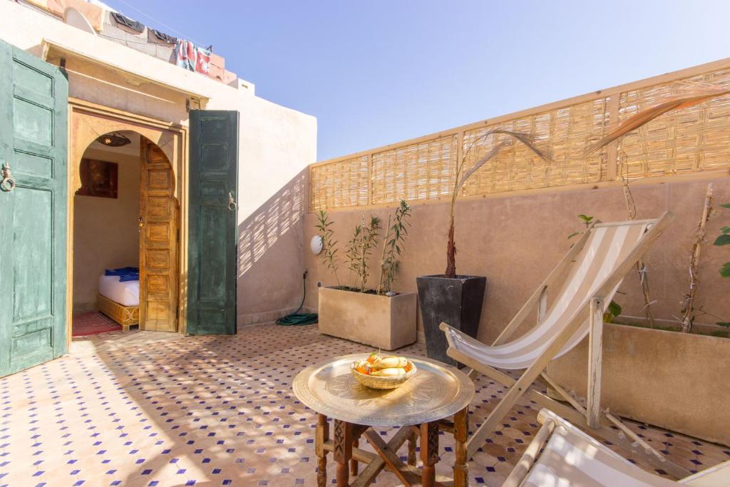 - un patio avec une table et un hamac dans un bâtiment dans l'établissement Riad Colette EXCLUSIF - Médina - Breakfast - Wifi, à Marrakech