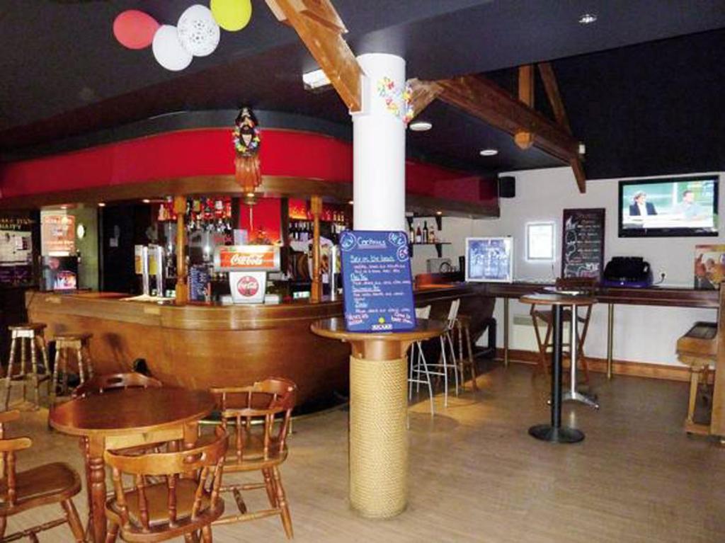 un restaurant avec un bar, des tables et des chaises dans l'établissement MH6pers-2ch-1sdb-lits faits-40m2-terrasse-tv--grand confort-empl calme-Kerlann, à Pont-Aven 15 autres photos