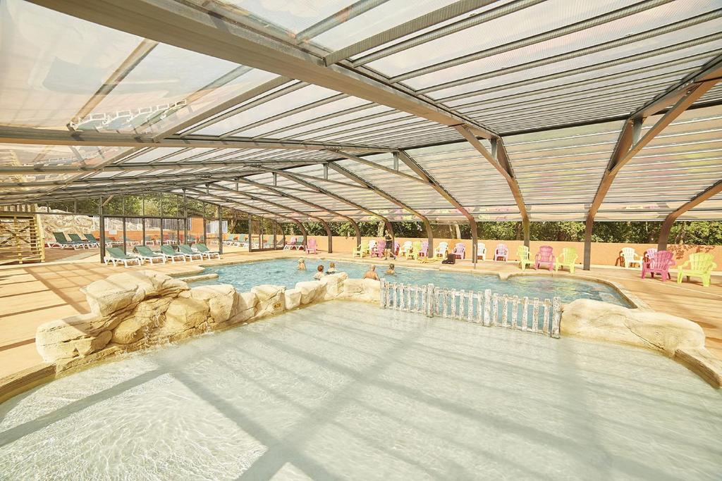 une grande piscine avec un plafond ouvert dans l'établissement Camping Les Albères - Maeva, à Laroque-des-Albères