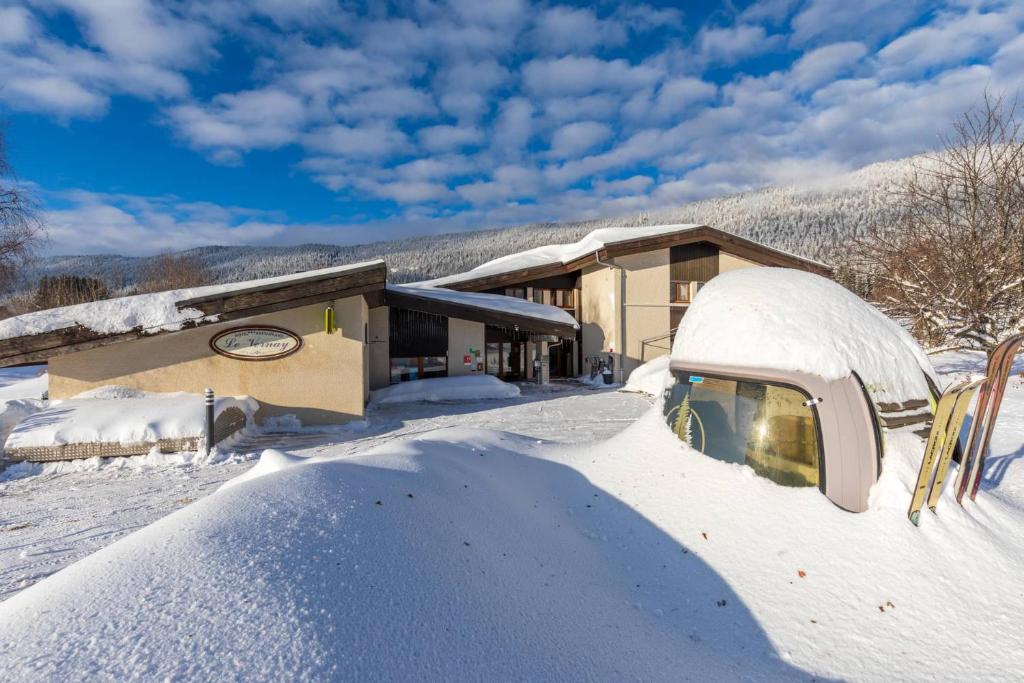 une maison avec un tas de neige devant elle dans l'établissement Logis Le Vernay, à Autrans