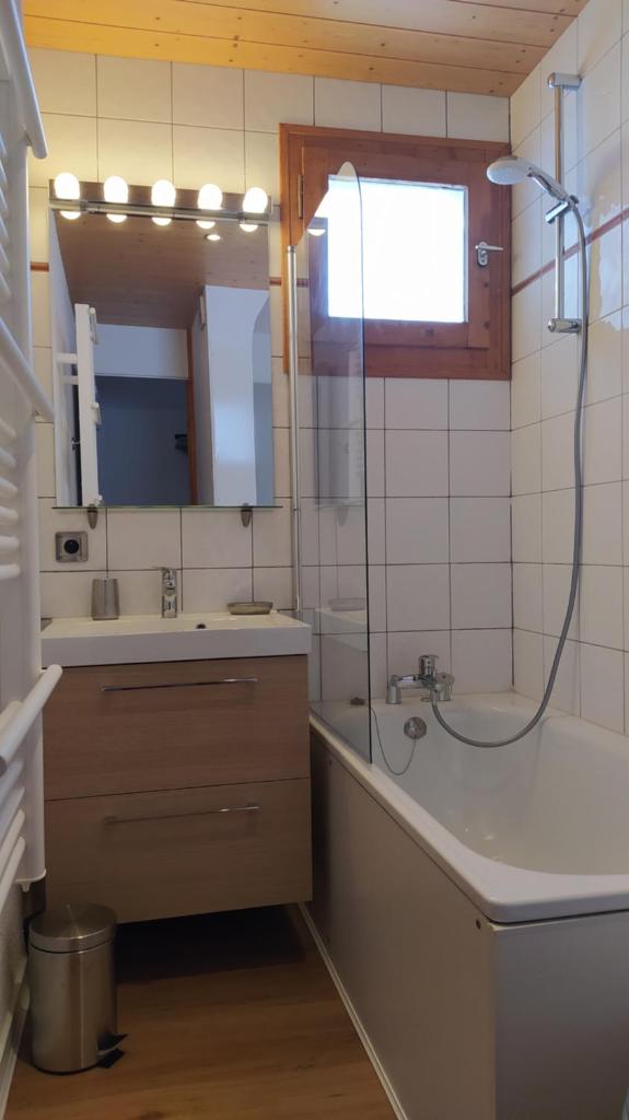 une salle de bain avec une baignoire, un lavabo et un miroir dans l'établissement PARADISKI-BELLE PLAGNE, Altitude 2050m, APPART skis aux pieds 4 personnes, à La Plagne Tarentaise