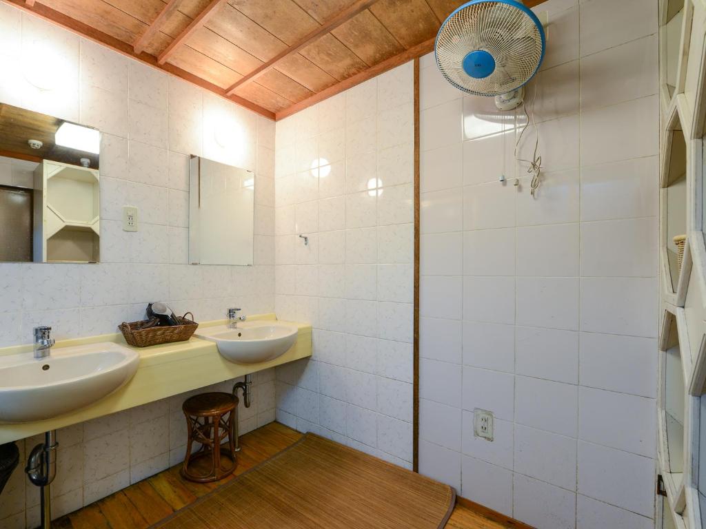 La salle de bains est pourvue de 2 lavabos et d'un ventilateur. dans l'établissement Shokinkan, à Yasugi