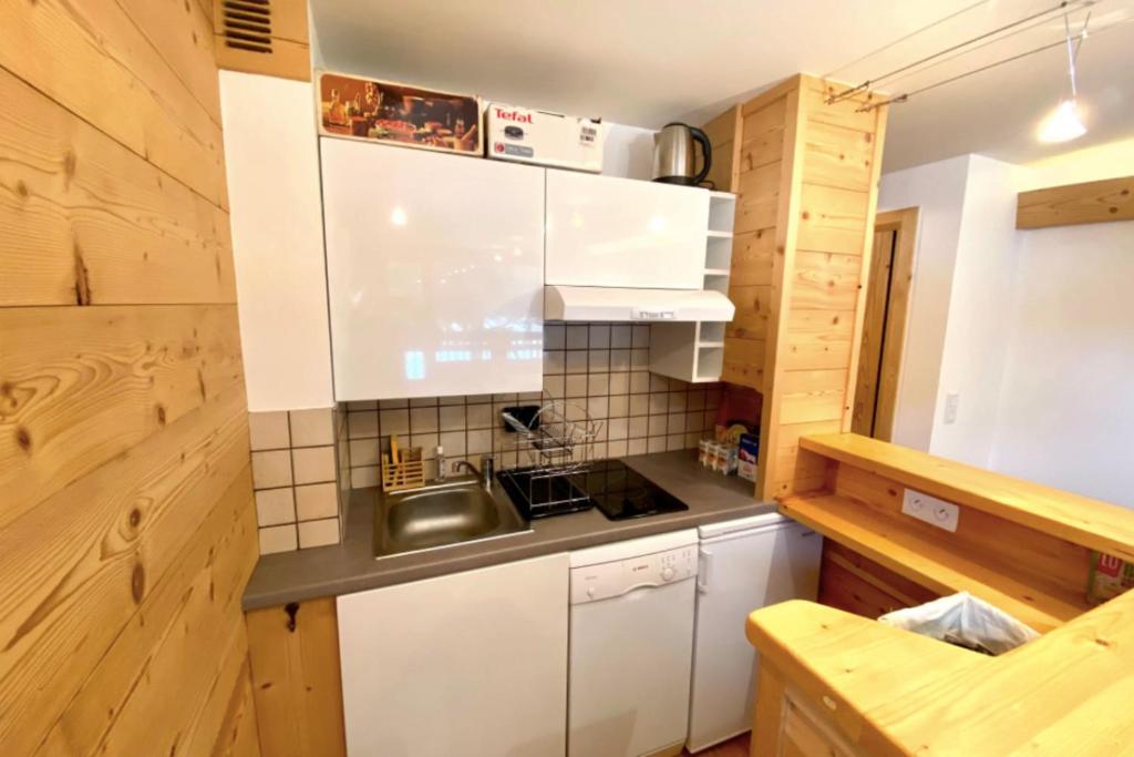une petite cuisine avec des armoires blanches et un évier dans l'établissement Charming Apartment With Swimming Pool, à La Salle Les Alpes