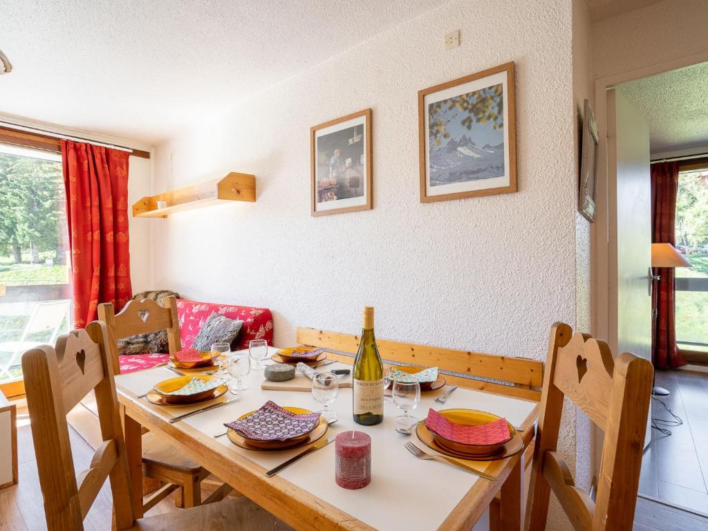- une table à manger avec une bouteille de vin dans l'établissement Apartment Pegase Phenix-16 by Interhome, au Corbier