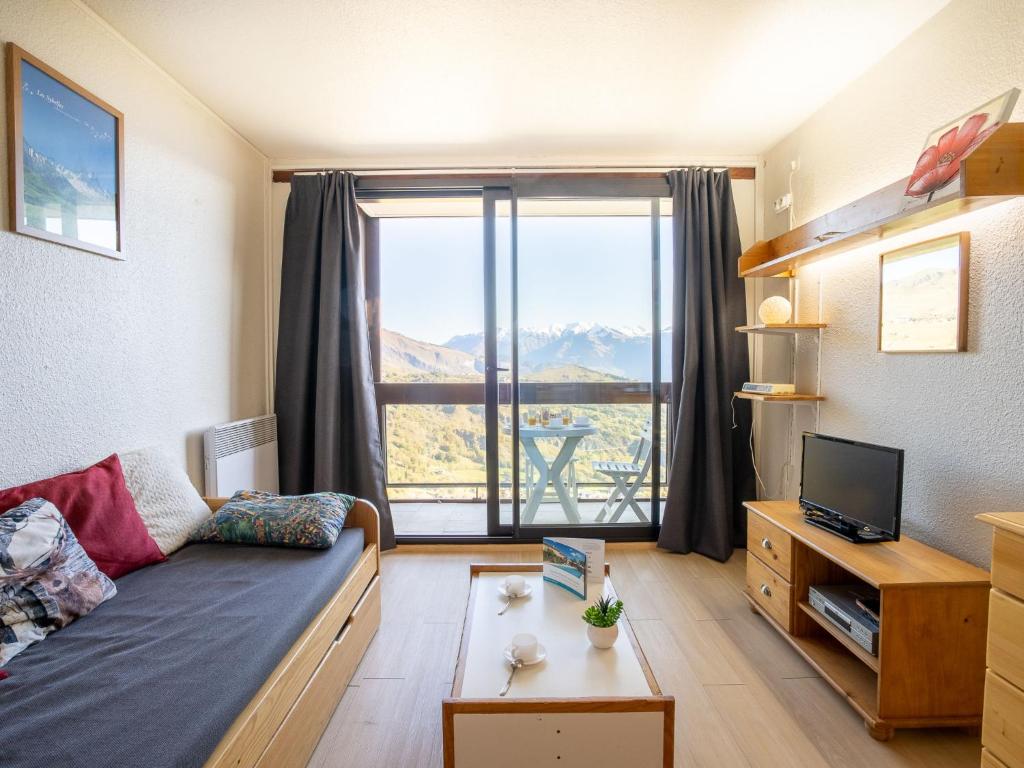 un salon avec un canapé et une grande fenêtre dans l'établissement Apartment Pegase Phenix-21 by Interhome, au Corbier