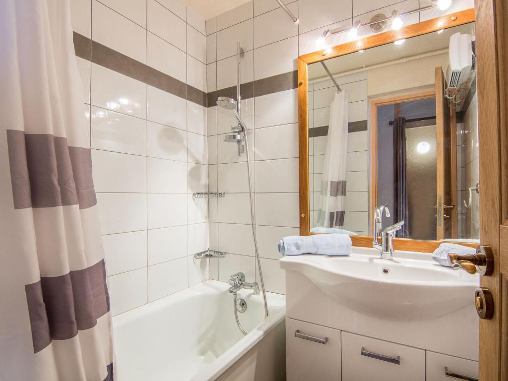 une salle de bain avec un lavabo, une baignoire et un miroir dans l'établissement Studio Pegase Phenix-44 by Interhome, au Corbier